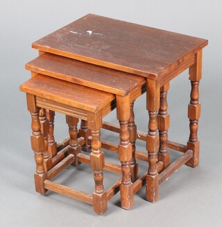 A nest of three rectangular interfitting coffee tables raised on turned and block supports 46h x 48w x 33d