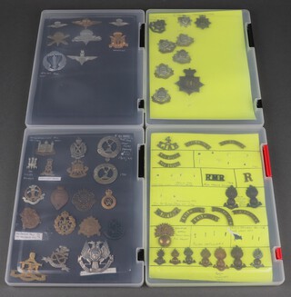 A collection of military metal shoulder titles and collar dogs and a collection of re-strike military badges contained in 4 shallow cases 