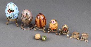 A parquetry wooden model of an egg 8cm, a lacquered egg 4cm and a collection of eggs and stands 