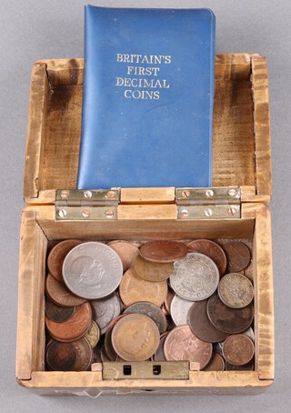 A collection of coinage contained in a walnut trinket box