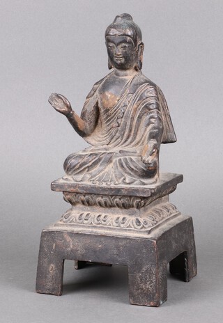 A Chinese cast iron figure of a seated deity, raised on a square base 28cm h 