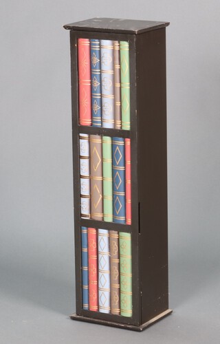 A cabinet with shelved interior enclosed by a panelled door with faux book decoration 84h x 23w x 19d