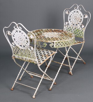A circular Bistro style pierced metal garden suite comprising table (a/f) and 2 folding chairs 