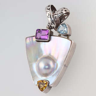 A stylish silver mounted keystone shaped pendant set mother of pearl and semi-precious stones 6cm 
