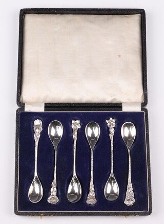 A cased set of 6, possibly South African, white metal spoons, each decorated a different flower 
