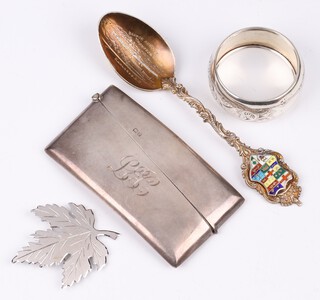 A silver card case, monogrammed, Birmingham 1914 by William Henry Sparrow, an engraved silver napkin ring Birmingham 1909, a Sterling brooch in the shape of a maple leaf together with an enamelled souvenir spoon, 83 grams 