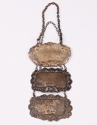 An embossed silver decanter label Birmingham 1973, 1 other 1974 - Scotch and Gin, by Roberts & Dore Ltd.,  21 grams, together with a silver plated Brandy label 