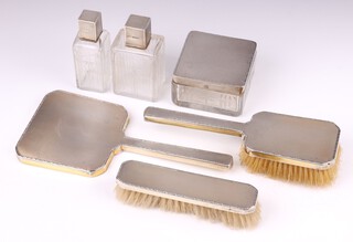 An Asprey, Art Deco, 6 piece silver gilt backed dressing table set comprising hand mirror, hair brush, clothes brush, square cut glass jar with silver insert 5cm x 9cm x 8cm and 2 rectangular cut glass scent bottles, London 1935, with Jubilee hallmark 