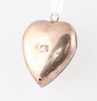 A gold marked 9ct heart shaped locket set a red stone, 1.7 grams gross