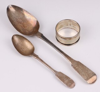A William IV silver fiddle pattern table spoon, London 1823, a silver fiddle pattern teaspoon London 1888 and a silver napkin ring, 106 grams