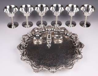 An engraved silver plated salver with bracketed border 38cm, a 3 piece silver plated condiment set and 6 plated champagne coups  