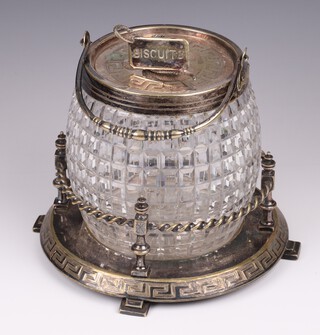 A cut glass biscuit barrel with plated mounts and a silver plated stand 