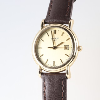 A lady's Tissot wristwatch contained in an 18ct gold case, with gold dial, calendar aperture and quartz movement, the reverse with inscription, 20 grams gross including leather strap and movement  