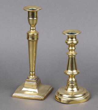 An 18th Century circular polished brass candlestick 18cm h (base misshapen) together with an 18th/19th Century Adam style candlestick on a square base 24cm (slightly misshapen and with solder repair) 