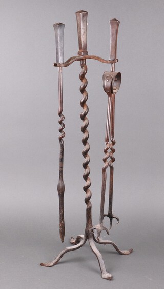 A blacksmith made wrought iron fireside companion set with tongs and poker, on a cruciform base (brush missing) 76cm h x 29cm w 