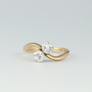 A gold testing as 18ct, 2 stone old cut diamond cross over ring, approx. 0.25ct, size N, 3.2 grams 