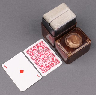 Two sets of playing cards contained in a leather finished box with tooled gilt decoration  8cm x 5cm x 4cm 