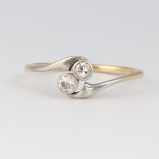A gold testing as 18ct, 2 stone diamond cross over ring, size Q, 2.2 grams 