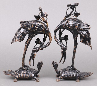 A pair of Japanese black painted bronze figures of storks standing on turtles 20cm 