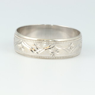 A 9ct white gold wedding band with engraved decoration, size Q 1/2, 2.9 grams