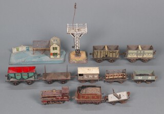 A collection of early Hornby Meccano to include a MLL2710 locomotive, 8 wagons and trailers, a signal tower and a train platform 