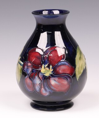 A Moorcroft  blue ground clematis pattern vase, base impressed Moorcroft and with paper label Potter to the Late Queen Mary 18cm 
