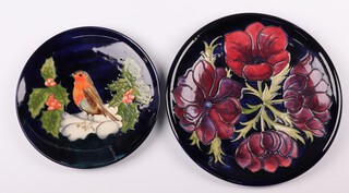 A Moorcroft blue glazed Robin & Holly plate, designed by Sally Tuffin, the base impressed Moorcroft 21cm diam and a William Moorcroft anemone pattern plate, 26cm 