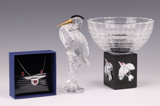 Kazumasa Nagai for Swarovski, a bowl (chips to base) 13cm on a stand, a Swarovski figure of a stork 14cm, and a ditto heart shaped necklace with a pair of ear studs 
