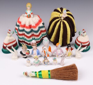 Two 1930's knitted tea cosies with porcelain dolls heads, 2 egg cosies with chicken's heads, a porcelain headed table brush, 9 various pin cushion heads and 3 pairs of legs 