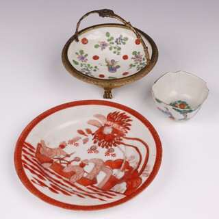 A Qing dynasty cushion shaped bowl decorated figures 3cm together with a circular floral pattern bowl with gilt metal mounts 8cm and a Japanese plate decorated figures in a boat 15cm