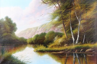 Andrew Grant Kurtis M.A. (British, born 1963), river scape with trees and mountains in distance, oil on canvas 59cm x 90cm, artist stamp verso, within a gilt frame 