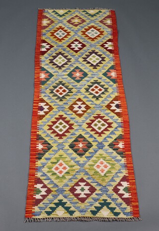 A green, turquoise and orange ground Chobi Kilim runner with all over stylised diamond design 197cm x 66cm 