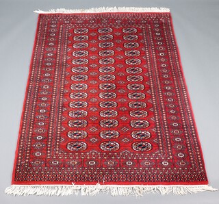 A red, black and white ground Afghan rug with 42 octagons to the centre within a multi row border 208cm x 139cm 