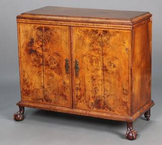 A Queen Anne walnut cabinet with moulded cornice, the interior fitted 2 drawers above cupboard fitted and 2 drawers flanked by 6 drawers, above 3 short drawers, enclosed by panelled doors, formerly the top of a chest on stand, raised on later cabriole ball and claw supports 90cm h x 100cm w x 45cm d 