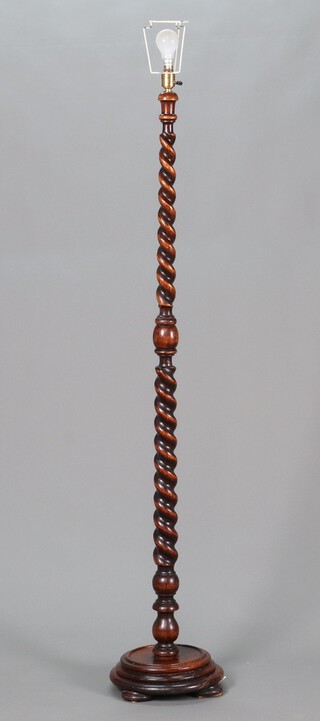 A 1930's spiral turned oak standard lamp raised on a circular base 163cm h x 35cm diam. 