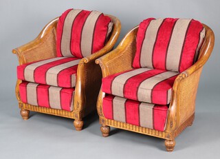 Multiyork, a pair of "cherry" tub back double cane bergere armchairs, raised on bun feet, complete with cushions upholstered in striped material 81cm h x 77cm w x 61cm d 