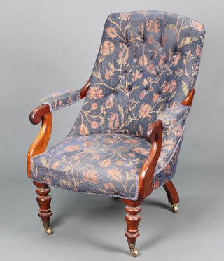 A William IV mahogany show frame armchair upholstered in blue floral material, raised on turned supports with brass caps and casters 96cm h x 61cm w x 59m d 