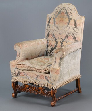 A 1930's Queen Anne style armchair upholstered in tapestry material, raised on cabriole supports with pierced wavy stretcher 116cm h x 73cm w x 70cm d 