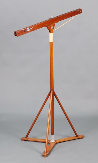 A wooden adjustable catapult designed for and used in the 1955 movie "The Dam Busters" by Michael Redgrave (playing Sir Barnes Wallis). The catapult represents that used by Wallis in his 1941 April Bank holiday garden marble experiments, to prototype the concept of the bouncing bomb.  The catapult raised on triform base and mounted on metal collar with tripod supports. The catapult firing rail adjustable in angle by a wing nut, having a projectile receptical attached to elastic cord running along the top rail of the device.  The rail fitted a trigger to release the projectile. 138cm h, catapult rail 93cm l
