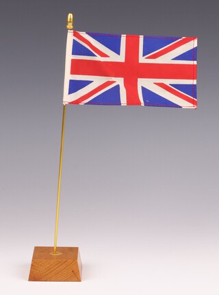 A Union Jack desk flag on gold flagpole with wooden base 27.5cm h