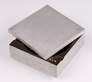 A B Kirkbride Associates for The British Aluminium Company, an Aluminium Alloy BA.24.WP machined and hand finished ashtray with barked edge, the interior monogrammed B.N.W. 11cm x 11cm together with an explanatory slip of paper.  
