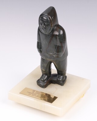 An Inuit carved hardstone figure of a standing Inuit, raised on a white onyx base with gilt metal plaque marked Sir Barnes Wallis, In Appreciation Canadian 617 Squadron, 24th September 1977 (plaque is loose), the reverse of the figure labelled Canada Eskimo Art, on a revolving base  20cm x 13cm x 13cm