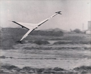 A 1950's black and white photograph of a remote Vickers Swallow swing-wing aircraft during testing 29cm x 37cm