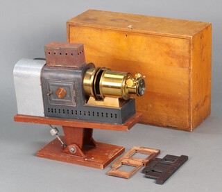 An early 20th Century magic lantern, converted to electricity, contained in an  aluminium and painted metal case with brass lens housing, the cover marked RD No. 230577 6in, raised on a wooden adjustable stand 39cm h x 51cm w x 19.5cm d,  together with a Dallmeyer 12" F/7-7 Dallon Tele-Anastigmat 200766 lens with Air Ministry marking to the interior, complete with wooden carrying case 42.5cm h x 59cm w x 22cm d.  Most likely used by Sir Wallis for his lecturing.
