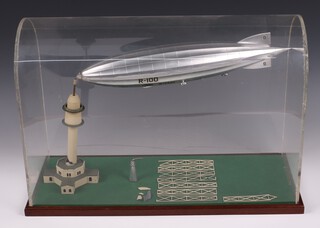A plastic diorama depicting the R.100 airship docked its mooring mast in St. Hubert Airfield, Quebec, Canada on August 3, 1930. 36cm h x 55cm l x 22cm d.  The model visible in the background of many photos of Barnes Wallis' office and depicts the R.100 after its 78 hour transatlantic flight to Canada.