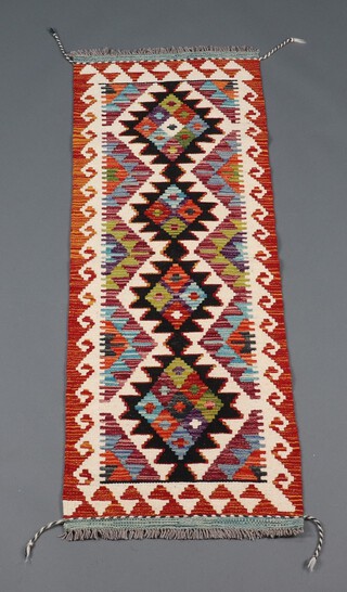 A black, white and orange ground Chobi Kilim runner with 4 stylised medallions to the centre 148cm x 49cm 