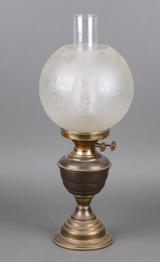 A gilt metal oil lamp complete with shade and chimney 