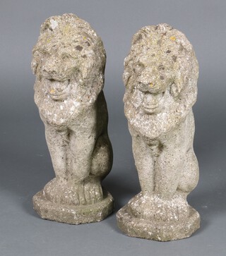 A pair of well weathered concrete garden figures of standing lions 46cm h 