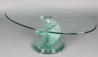 After Danny Lane, an oval glass table, raised on a stepped spiral base 40cm h x 118cm w x 65cm d 