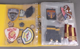 A collection of Continental military and Police cloth insignia contained in yellow ring bound file 